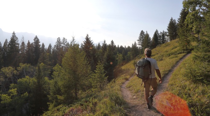 man hiking at a crossroad in the path mountains