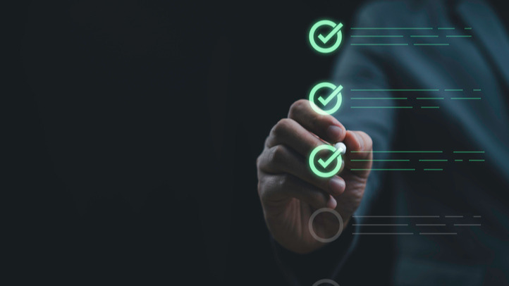 A man & woman sit together at a table, focused on a tablet, discussing B2B Commerce ROI and comparing thoughts.